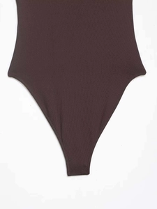 Detail of deep brown bodysuit featuring ribbed knit fabric texture and high-cut leg design