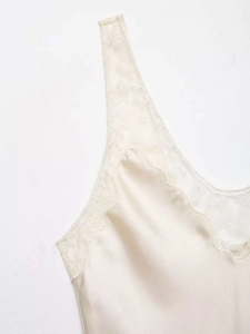 Détail du caraco en satin crème élégant avec bordure en dentelle délicate sur le col