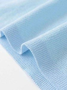 Close-up of light blue knit sweater fabric with detailed horizontal ribbed texture