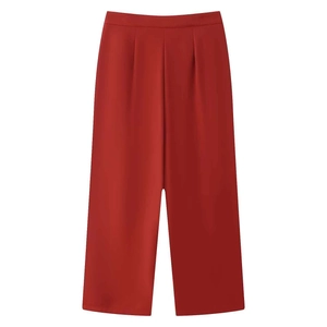Detail view of high-waisted dark red wide-leg trousers with elegant pleats and drape