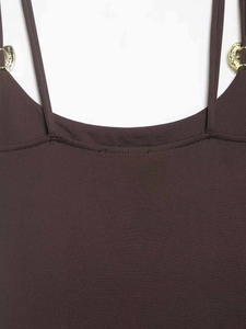 Detailed close-up of brown knit bodysuit with gold metal ring buckles on straps