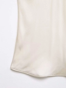 Gros plan sur le tissu en satin champagne montrant les coutures et le drapé lisse