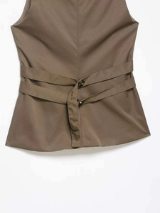 Detail of the back waist cinch on this khaki vest featuring two amber buttons and ties