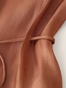 Detailed macro view of sheer brown tencel fabric with vertical texture and drawstring