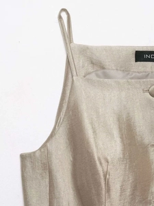 Detail of champagne satin top with square neckline and delicate matching buttons