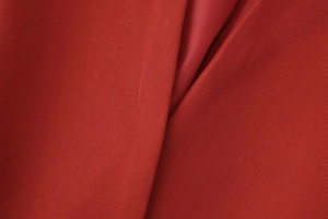 Close-up of red twill fabric texture and smooth matching lining for women's blazer suit