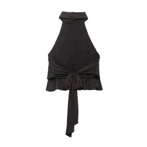 Detail of black halter top featuring high neck buttons and a large waist bow tie