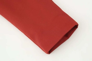 Close-up detail of dark red twill fabric stitching on suit sleeve and hemline