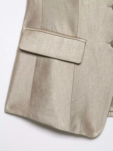 Detail view of champagne satin jacket showing fine stitching and pocket texture