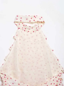 Detail of child halter top featuring red polka dots on cream fabric with neck buttons