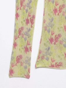 Détail du tissu en maille florale avec fleurs roses et mauves sur fond jaune vert