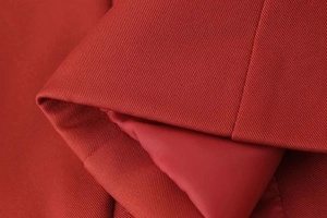 Detail of red blazer fabric with twill texture and smooth inner lining finish