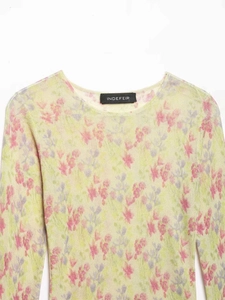 Gros plan du col de pull en maille à fleurs roses montrant la texture et l'étiquette