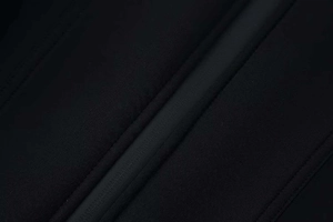 Detail of waterproof taped zipper and technical fabric on a black stand-collar jacket