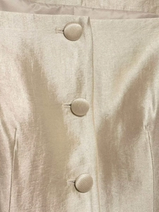 Detail of elegant champagne satin fabric with three matching fabric-covered buttons