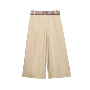 Détail d'un pantalon beige taille haute à jambes larges avec ceinture en cuir marron