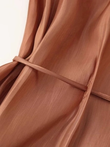 Macro shot of brown lightweight fabric with vertical texture and drawstring detail