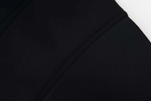 Close-up of black knit fabric showing premium stitching and uniform seam detail