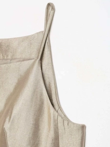Macro detail of champagne satin fabric with thin straps and refined edge stitching