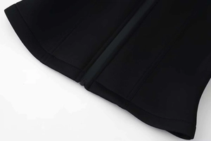 Detail view of the stand-up collar with high-quality zipper on the black cropped jacket