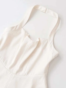 Detail of cream halter dress featuring pleated bust design and hidden side zipper closure