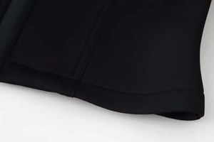 Detail view of black cropped jacket with vertical reinforced stitching and stand-up collar
