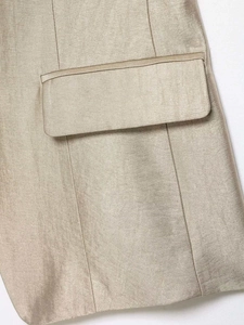 Close-up of champagne gold satin fabric texture and flat pocket detail on the women jacket