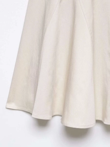 Detail of light apricot midi skirt showing twill fabric texture and clean stitching