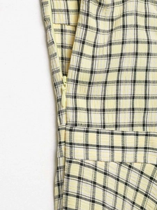 Detail des gelb-karierten Midikleids mit Stoffstruktur und verdecktem Reißverschluss