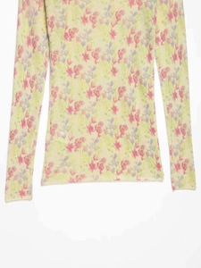 Détail du tissu en maille vert clair avec des motifs floraux roses délicats