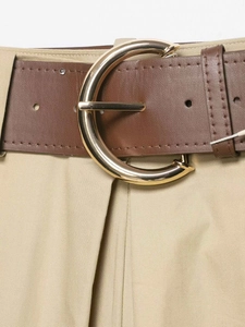 Gros plan d'une ceinture en cuir marron avec une grande boucle ronde dorée et brillante