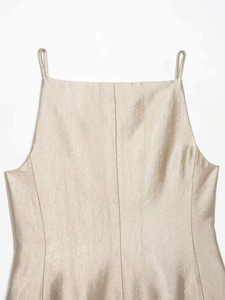 Detailed close-up of champagne satin fabric and delicate thin shoulder straps