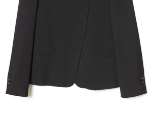 Detail of curved hemline and decorative sleeve buttons on black tailored blazer jacket