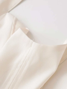 Close-up detail of cream white halter dress showing premium twill fabric and fine stitching