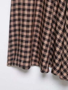 Detailed macro view of the brown and black checkered plaid fabric with twill texture