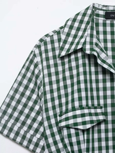 Detail of green and white checkered shirt dress showing pointed collar and chest pocket