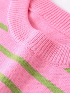 Gros plan sur le col rond côtelé et la maille rayée rose et verte de ce pull tendance