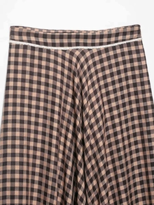 Detail of gingham check skirt featuring brown plaid fabric and white lace trim decoration