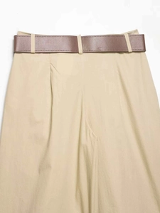 Détail du pantalon large kaki à taille haute avec ceinture en cuir marron et plis