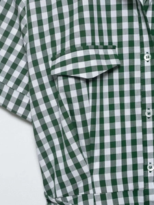 Detail of green gingham dress featuring a flap chest pocket and white round buttons