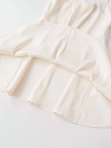 Detail view showing professional stitching and high-quality hem of the cream halter dress