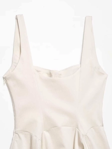 Detail view of structured beige midi dress with wide straps and invisible side zipper