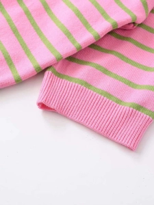 Vue détaillée des poignets et de l'ourlet en maille côtelée sur le pull rayé rose et vert