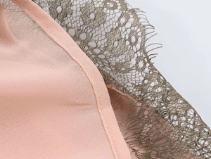 Detail of pink chiffon fabric with intricate grey eyelash lace and premium seam work