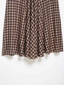 Detail shot of the brown gingham pattern and draped hem on this summer midi skirt