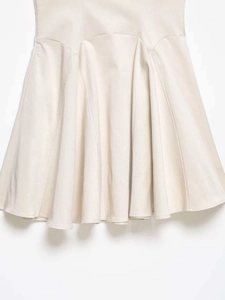 Detail of the flared A-line hem and paneled stitching on this apricot summer dress