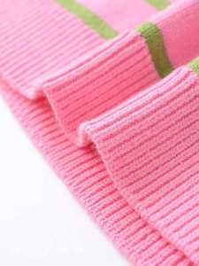 Gros plan du pull en tricot à rayures roses et vertes montrant la texture côtelée douce