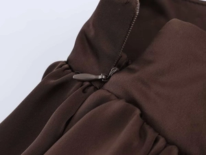Détail de la fermeture éclair invisible et du satin plissé sur une jupe marron