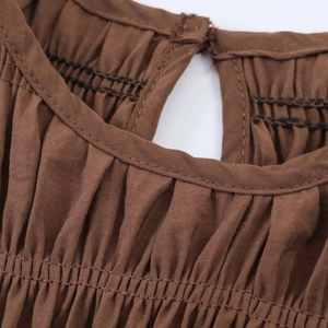 Detail of coffee brown cotton-linen dress featuring elastic smocked waist and button keyhole back
