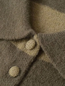 Macro detail of high-quality knit cardigan with contrast panels and wool texture